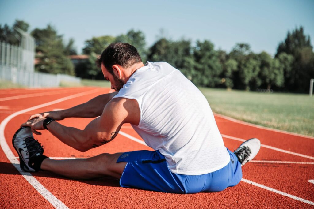 Man stretching his hamstring muscles to prevent injury- may not be the best option.